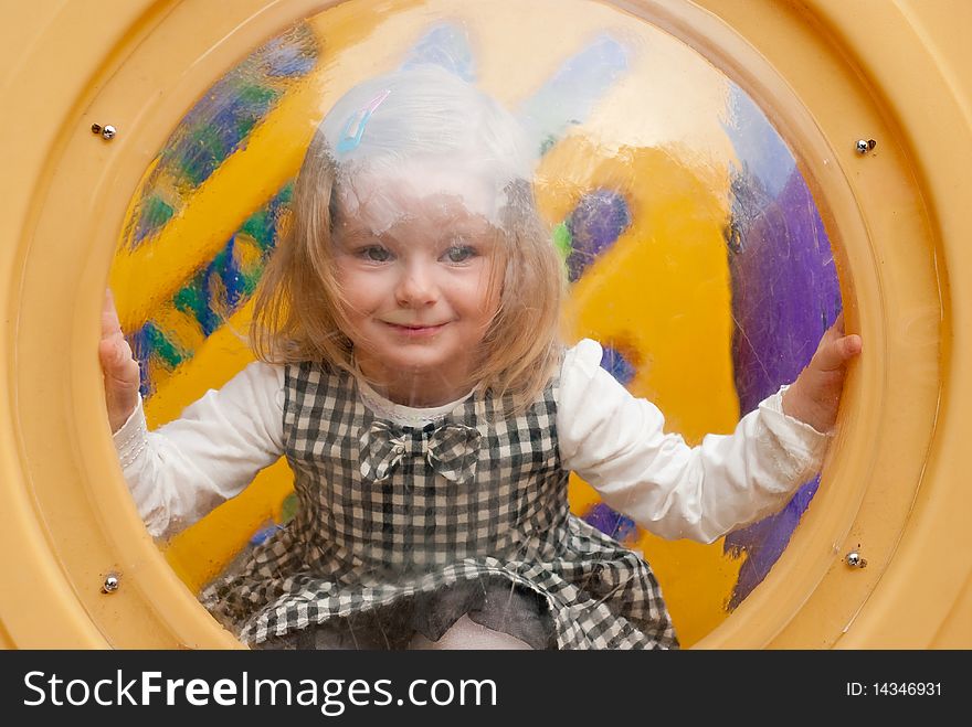 Smiling girl in porthole. Outdoor shot. Smiling girl in porthole. Outdoor shot