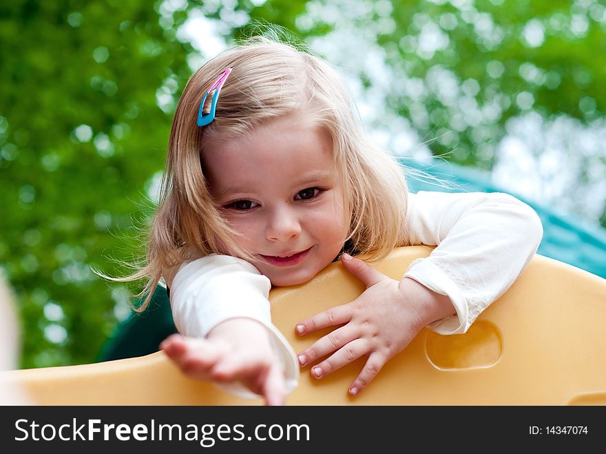 Little smiling girl in the playground.  Focus on face. Little smiling girl in the playground.  Focus on face