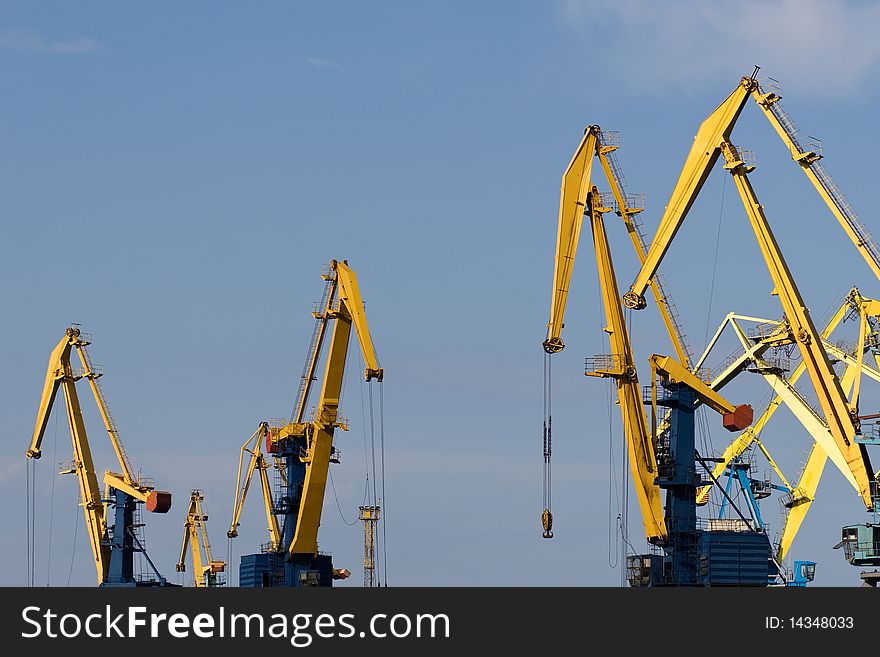 Four big industrial cranes at commercial dock