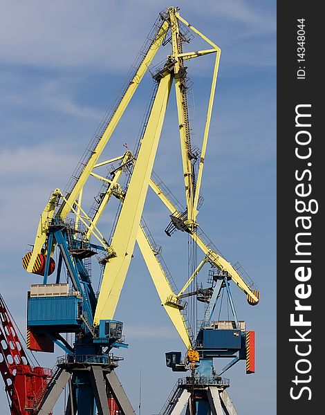 Two huge industrial cranes with blue sky at the background. Two huge industrial cranes with blue sky at the background