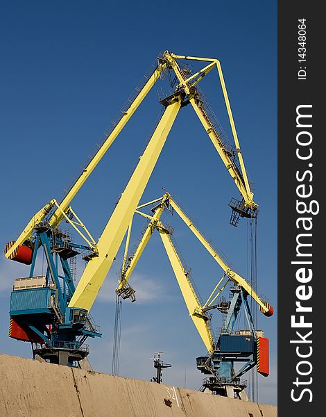 Huge industrial cranes working at the commercial dock. Huge industrial cranes working at the commercial dock