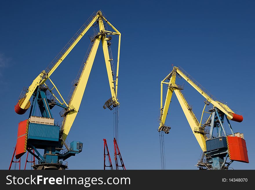 Cranes working under the clear blue sky. Cranes working under the clear blue sky