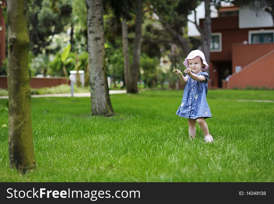 Adorable toddler girl playing with a grass on vacation