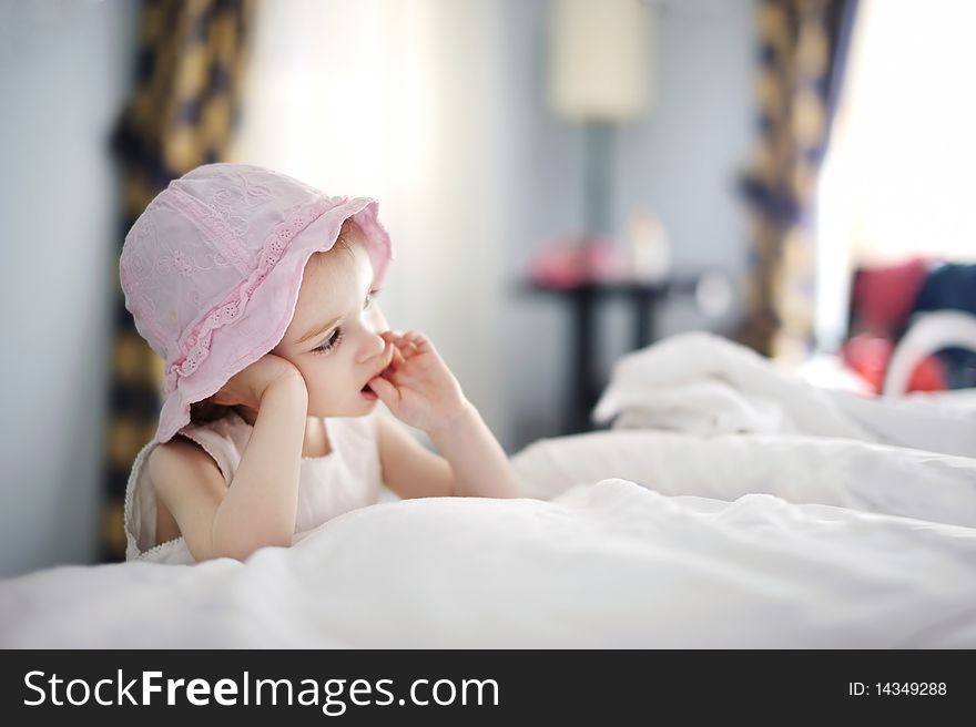 Thoughtful toddler girl in nice pink hat