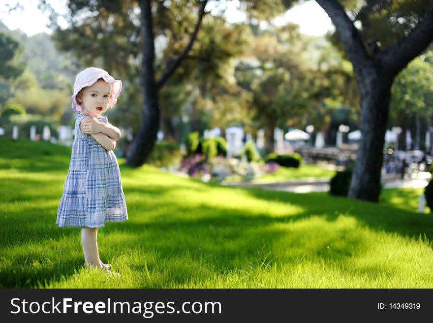 Adorable toddler girl in blue dress on a resort