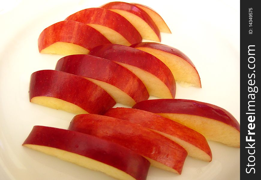 Red riped apples cutted and decorated in a glass plate. Red riped apples cutted and decorated in a glass plate.