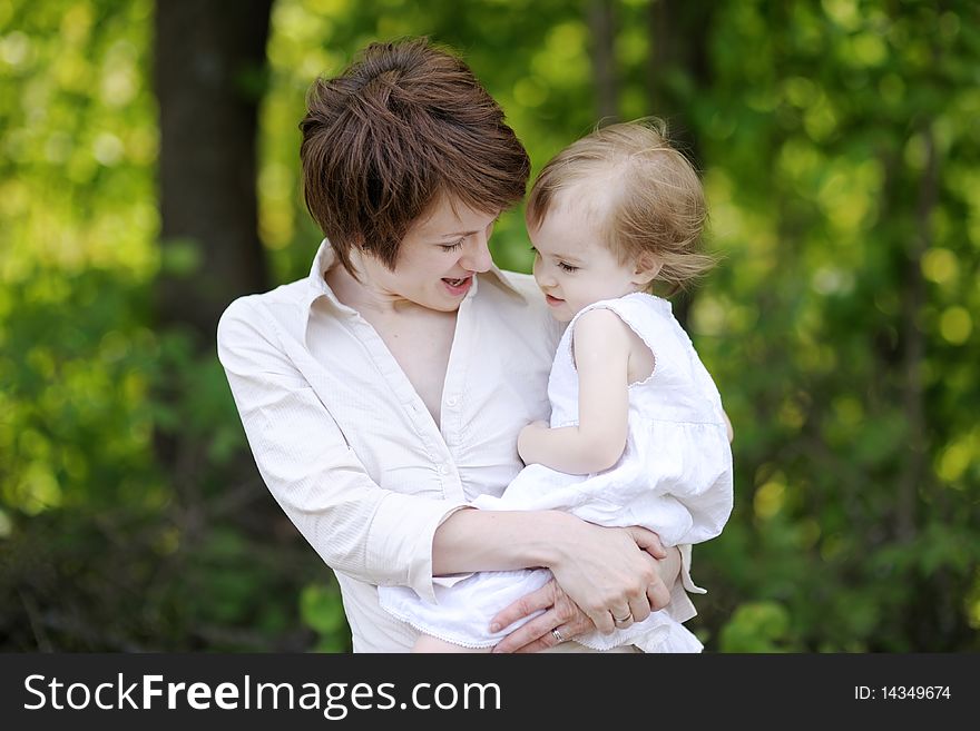 Young mother holding her adorable toddler girl. Young mother holding her adorable toddler girl