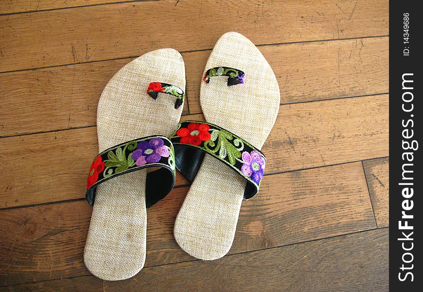 Pair of designer jute footwear with colorful flower design. Pair of designer jute footwear with colorful flower design.