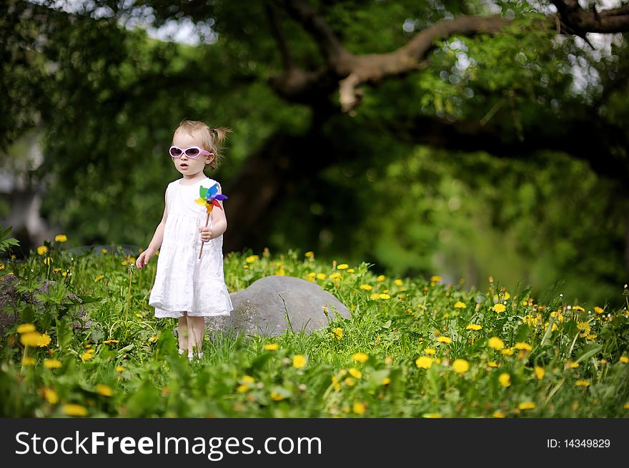 Adorable girl standing in dandelions field
