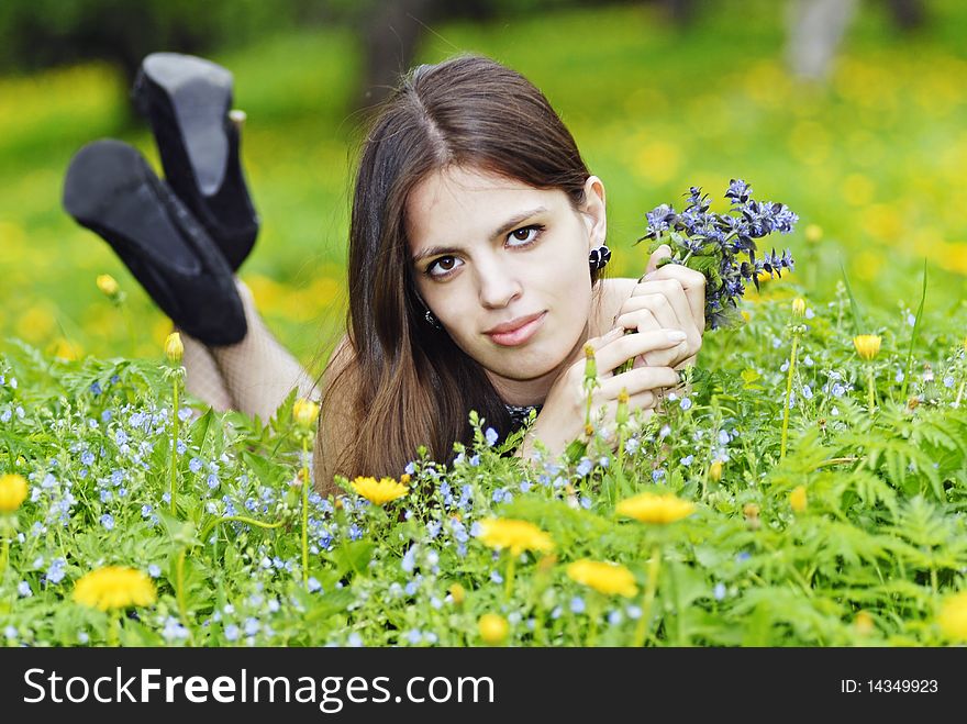 Girl Lying In A Grass With A Bunch Of Flowers