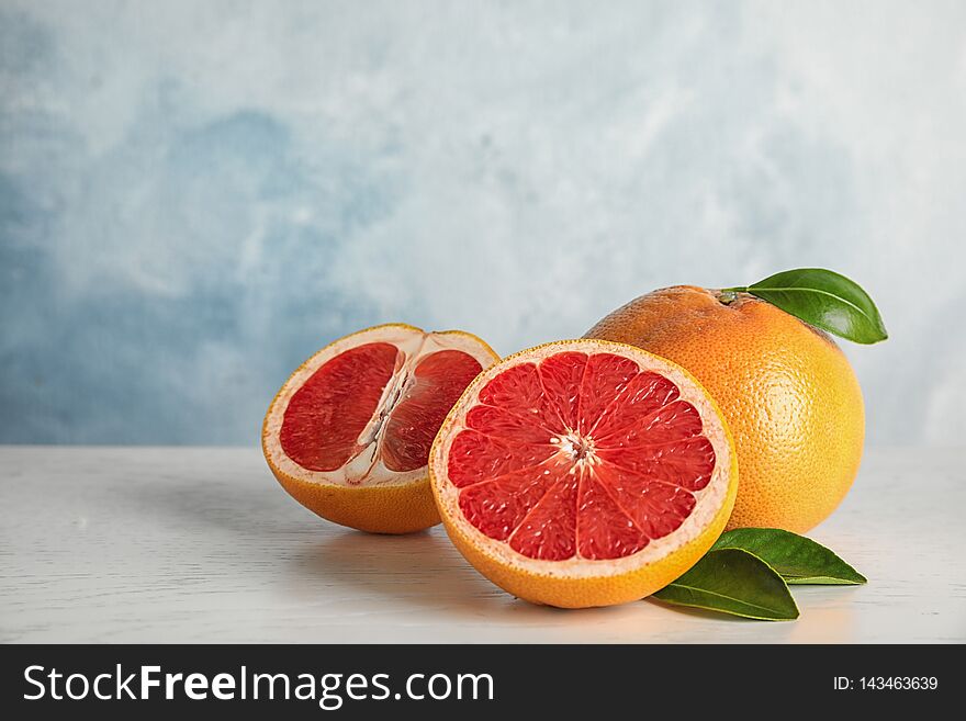 Fresh Grapefruits On Table Against Color Background. Space For Text