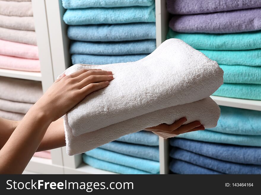 Woman holding towels near shelf, closeup view