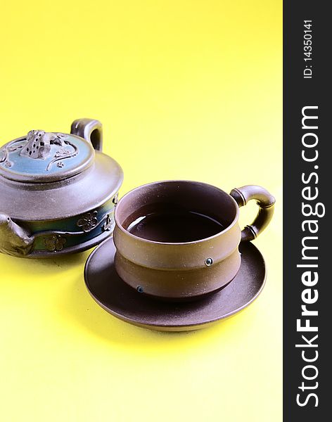 Chinese tea pot and cup isolate on yellow background