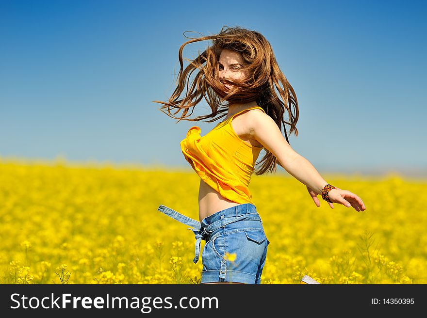 Young woman on blooming rape field