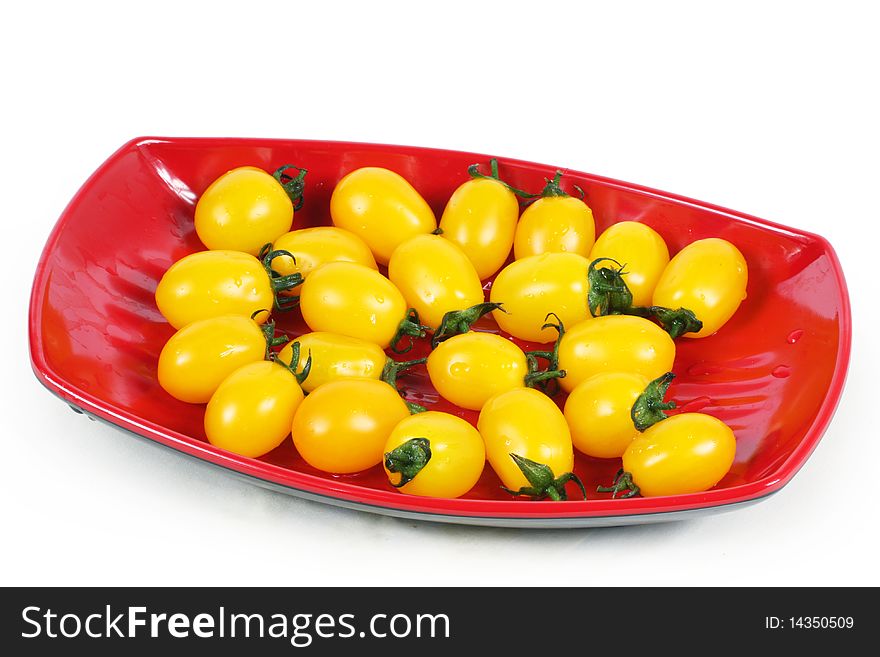 Yellow tomatoes in the red plate
