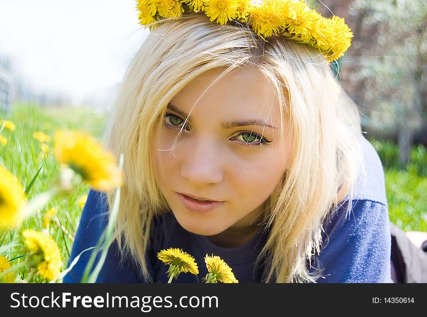 The girl lies in a grass with a wreath from colours on a head. The girl lies in a grass with a wreath from colours on a head