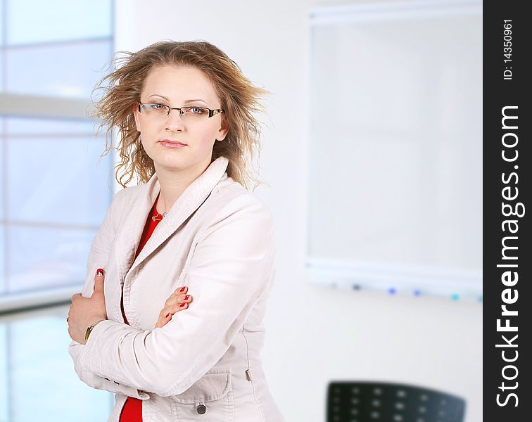 A pretty mature business woman standing in office. A pretty mature business woman standing in office