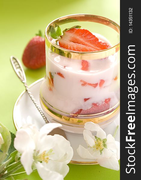 Strawberryyogurt with fresh strawberry in glass. On a 
green backgroundA