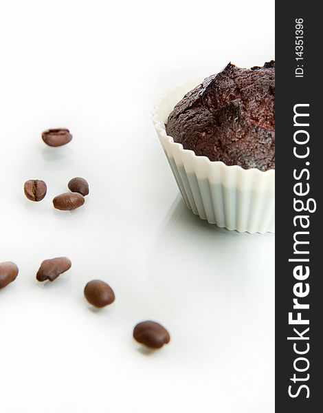 Chocolate muffin isolated on white background with coffee beans