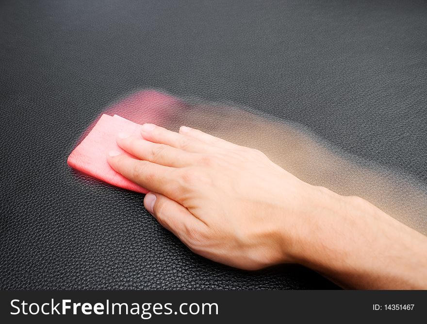 Hand wiping a leather sofa. Hand wiping a leather sofa