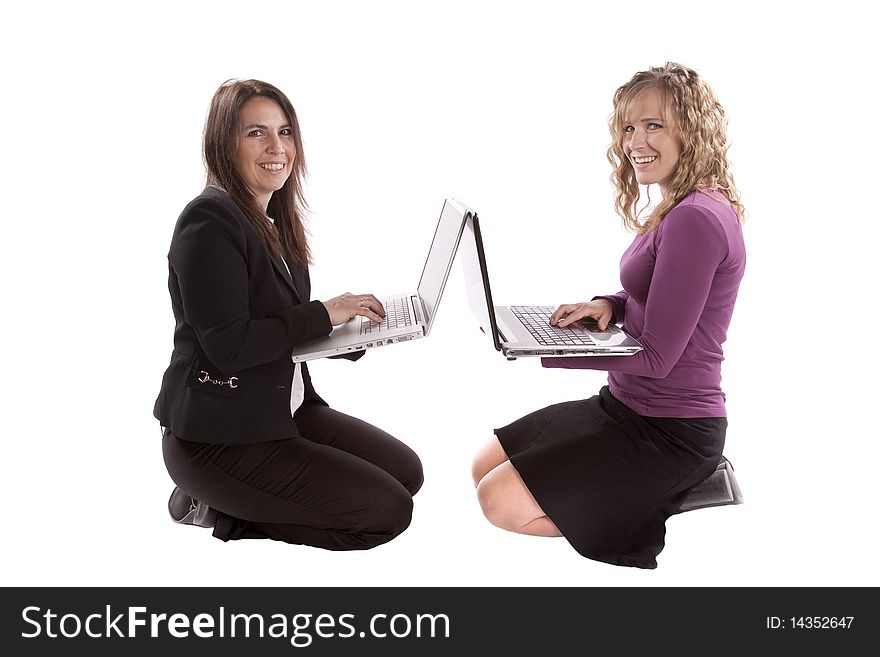 Two women have laptop computers back to back and are smiling. Two women have laptop computers back to back and are smiling.