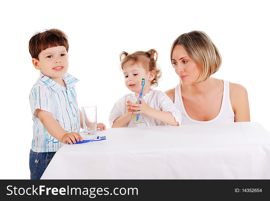 Young mother and her young daughter and son brushing teeth on a white background. Young mother and her young daughter and son brushing teeth on a white background