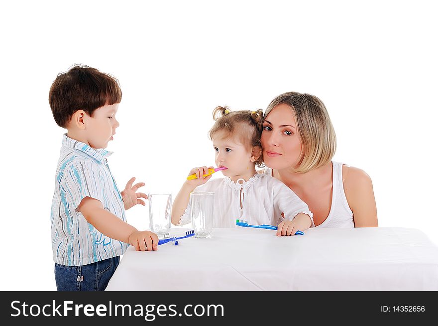 Young mother and her young daughter and son brushing teeth on a white background. Young mother and her young daughter and son brushing teeth on a white background