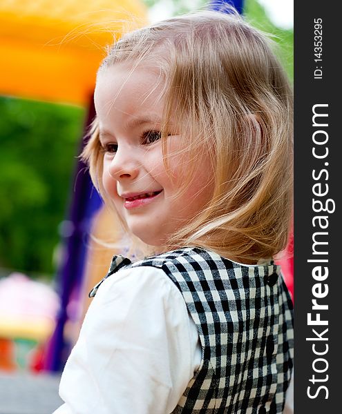 Little smiling girl in the playground.  Outdoor shot