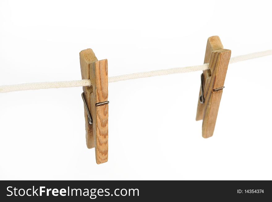 Two wooden clothes pegs on the string haging on the white background