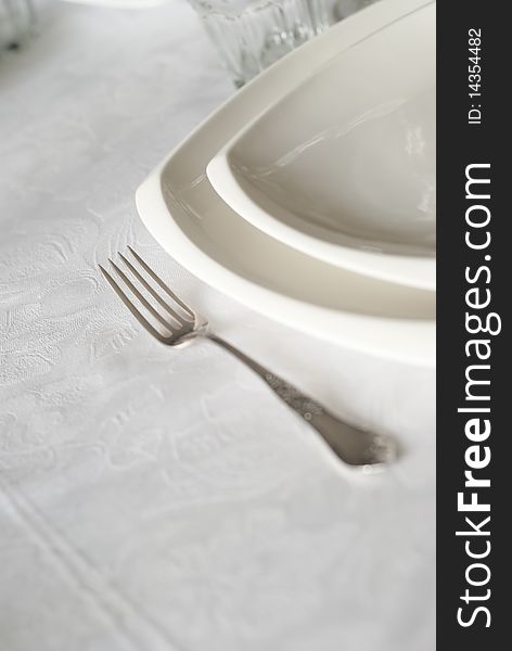 Silver fork with white plates on the table. Silver fork with white plates on the table