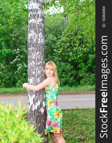 Beautiful young caucasian woman hugging a tree
