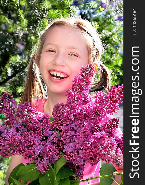 Young girl with lilac flowers on the green background. Young girl with lilac flowers on the green background.