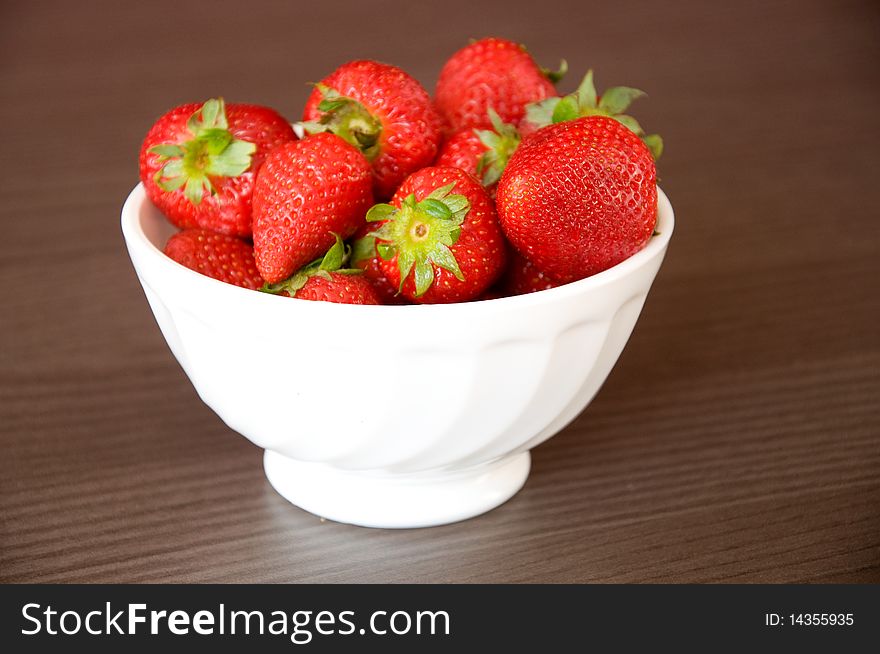 Bowl with strawberries on wooden table. Bowl with strawberries on wooden table