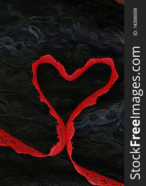 Red lace shaped as a heart on black lace. Red lace shaped as a heart on black lace.