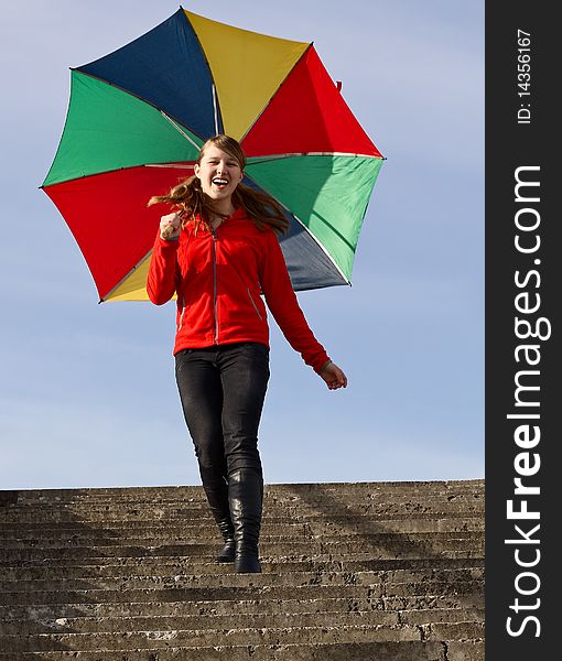 Happy girl with a colorful umbrella down the stairs. Happy girl with a colorful umbrella down the stairs