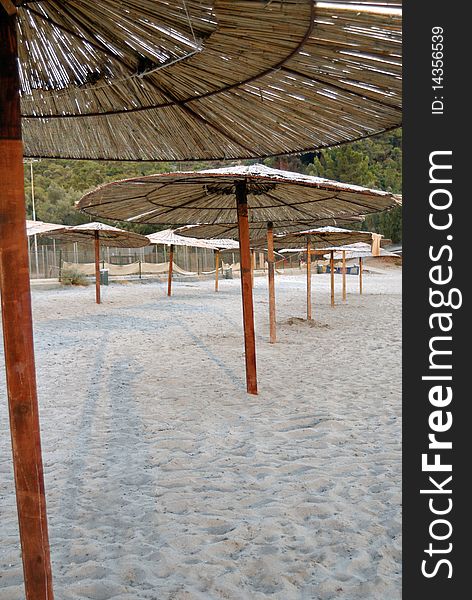 A sand beach with a bamboo umbrellas.