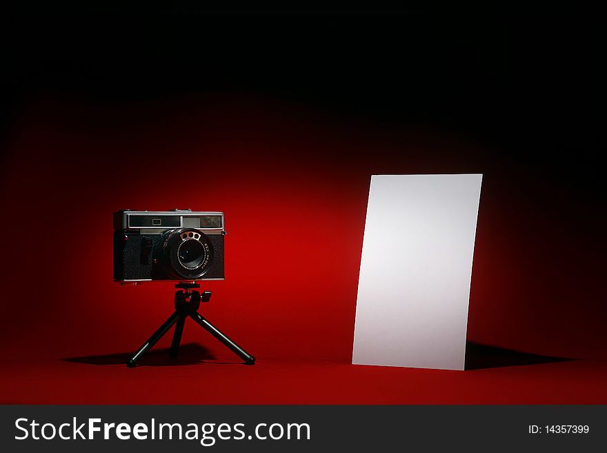 Retro camera and portrait blank photo on black and red background. Retro camera and portrait blank photo on black and red background.