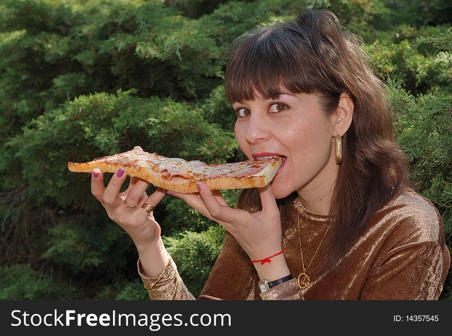 Young beautiful woman eating a big sandwich outdoors. Young beautiful woman eating a big sandwich outdoors.