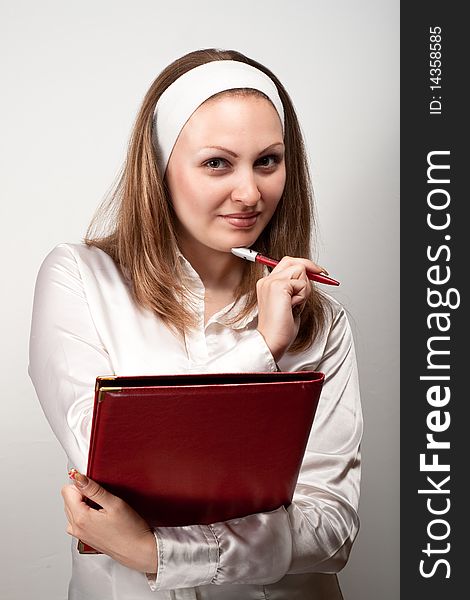 Pretty young nurse writing in red book