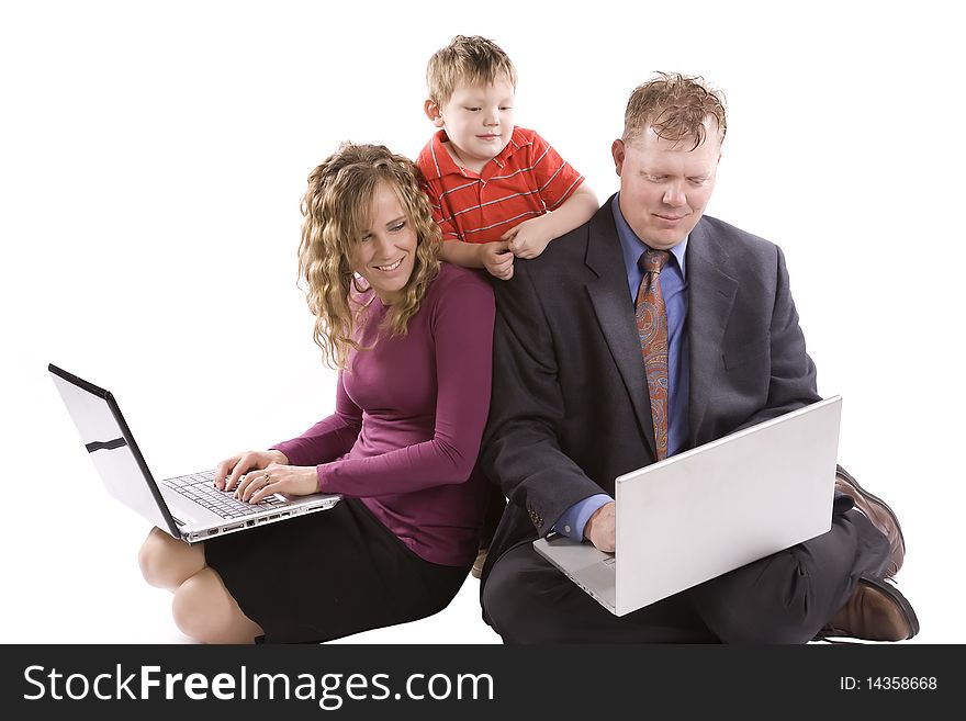 A family all looking at the computer held by the dad. A family all looking at the computer held by the dad