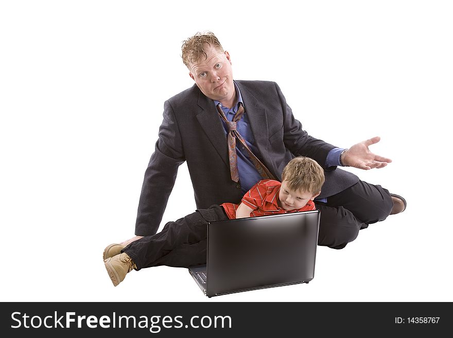 Son is working on a computer while dad looks surprised. Son is working on a computer while dad looks surprised.