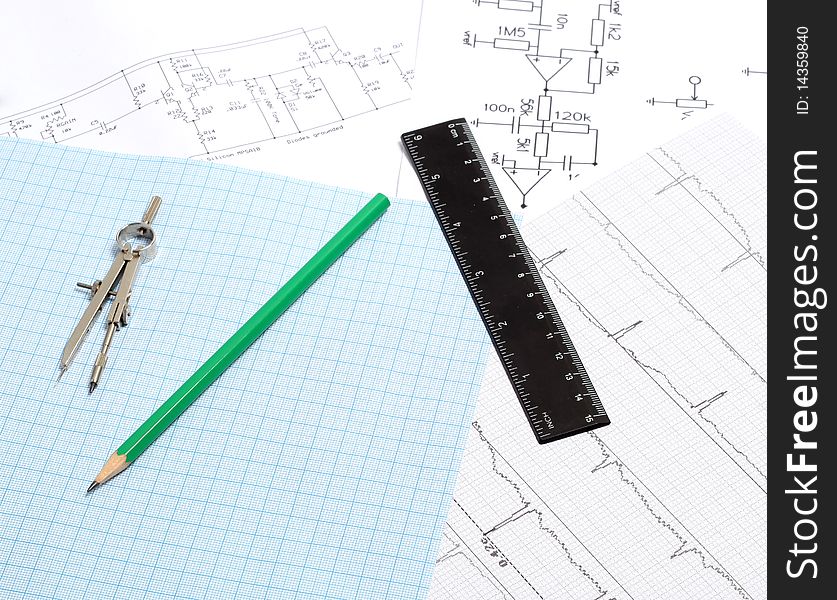 A drafting compass on a graph paper background with, line and green pen