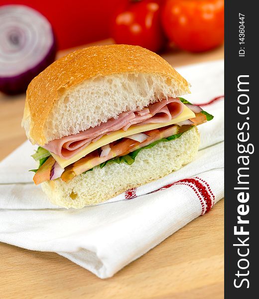 A ham and salad roll on a kitchen bench