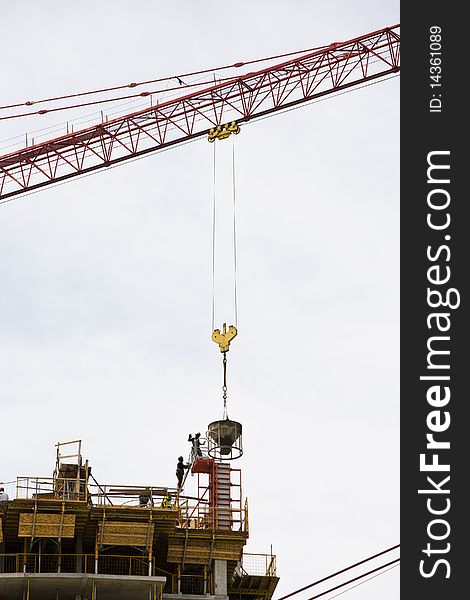 Condominiums being built with a crane on site and cement being poured in. Condominiums being built with a crane on site and cement being poured in