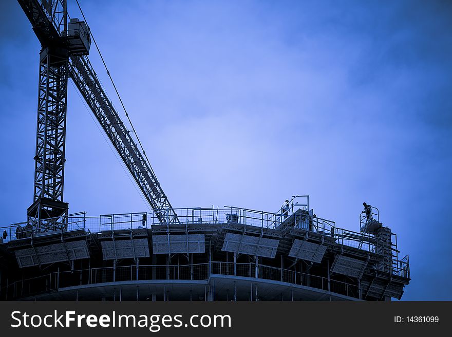 Condominiums being built with a crane on site. Condominiums being built with a crane on site