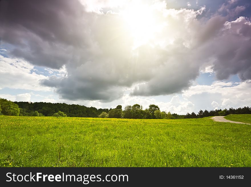 Spring landscape, green grass, dramatic sky