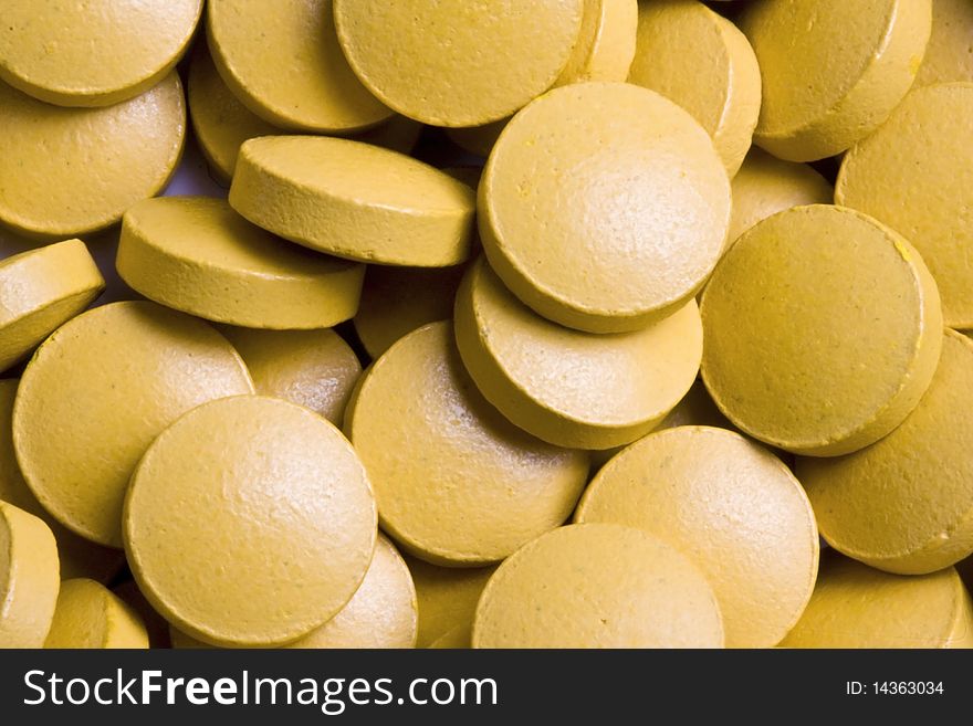 Yellow tablets background.Yellow tablets closeup