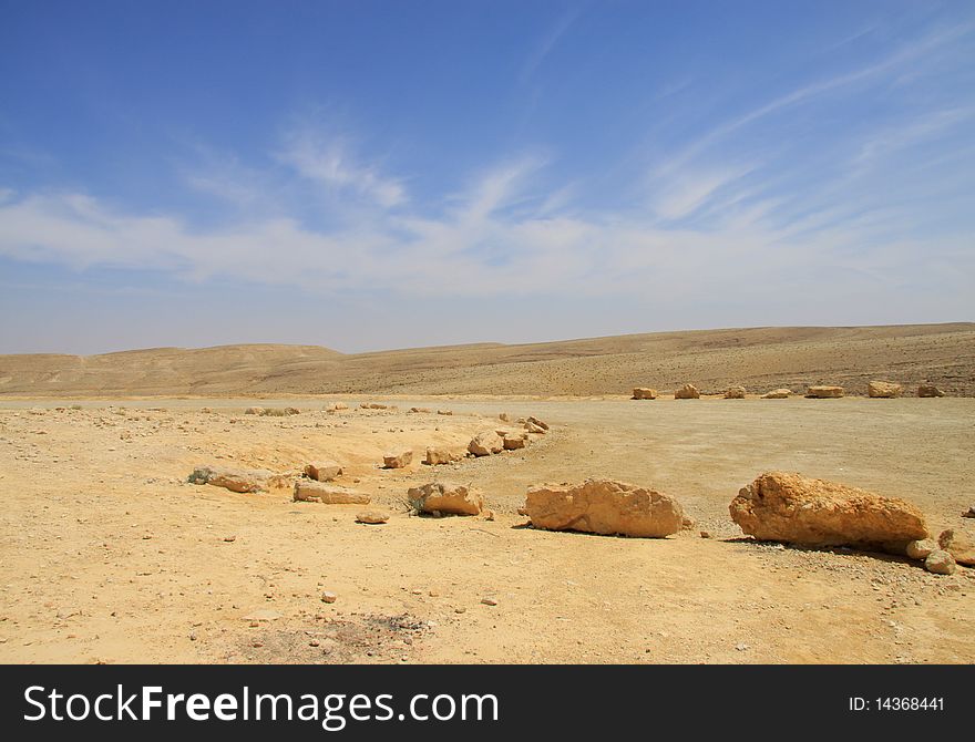 View on dry desert with yellow sand and rocks in Israel