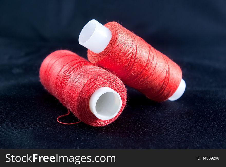 Two spools of red thread