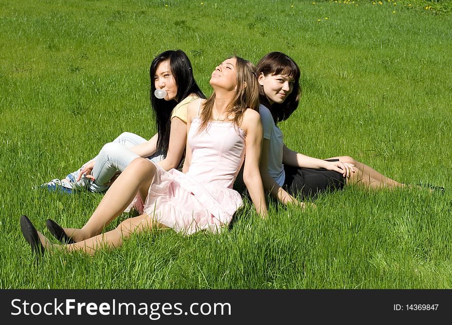 Three girls sitting on grass. Three girls sitting on grass